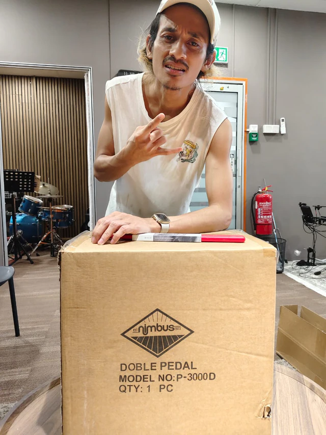 Customer with a boxed Nimbus P-3000D double pedal and drumsticks