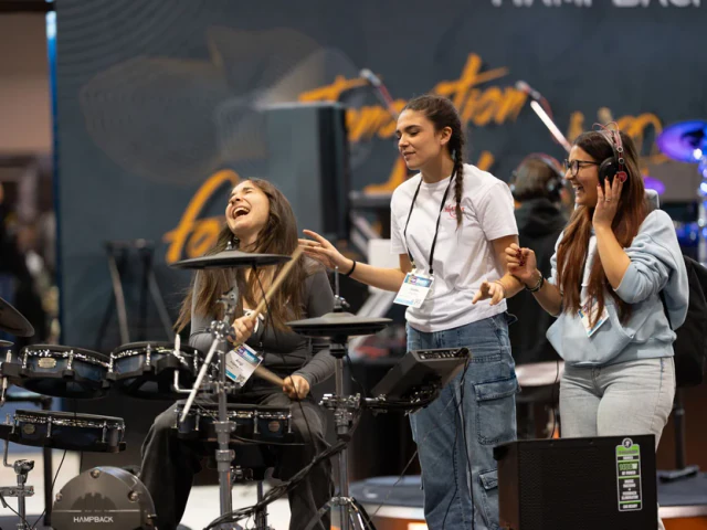 Visitors enjoying a Hampback electronic drum demonstration at NAMM