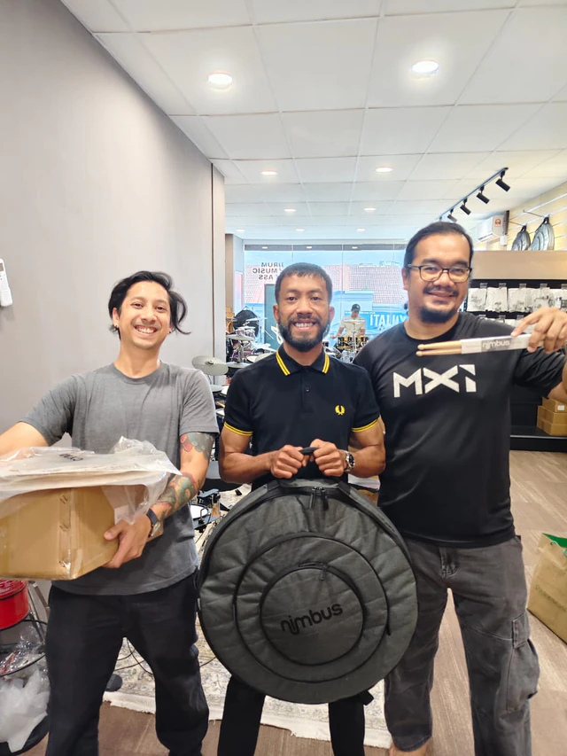 Customers with boxed equipment, a Nimbus bag and drumsticks
