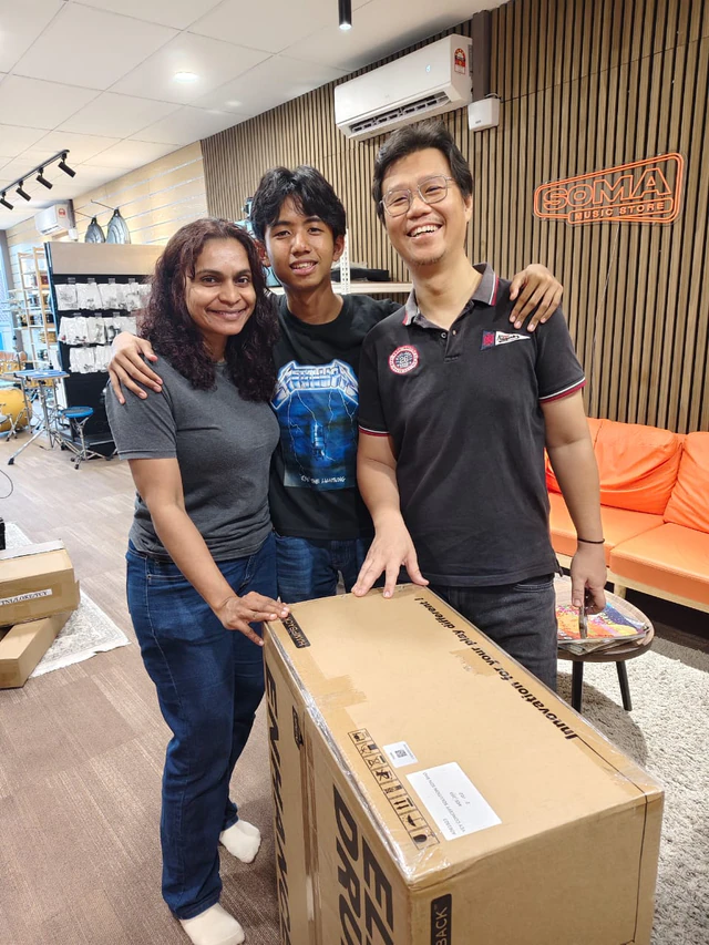 Soma Music customers collecting a boxed electronic drum kit at the Ampang showroom