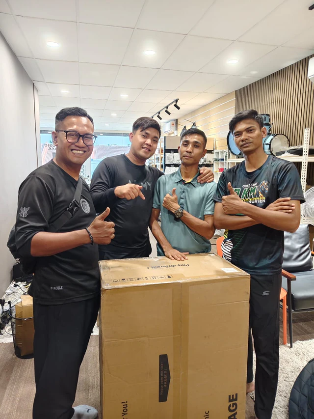Soma Music customers with a boxed digital drum kit inside the Ampang shop