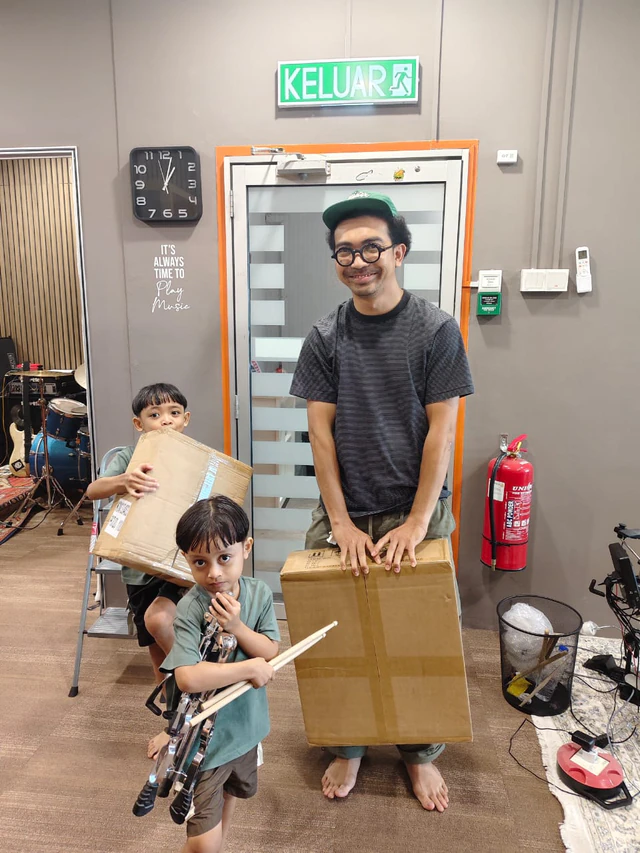 A family with boxed equipment and drumsticks at Soma Music